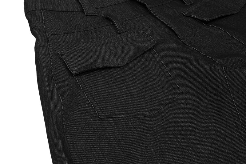 Close-up of black denim cargo pocket flap and side seam stitching