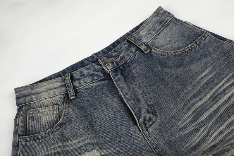 Close-up of waistband and front pocket area on blue washed denim jeans