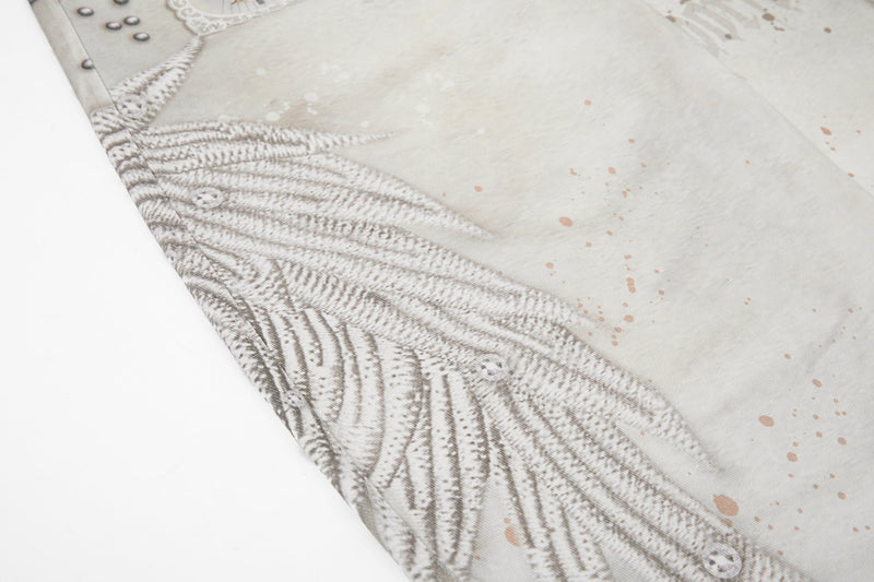 Close-up of wing graphic across cream denim with light splatter print