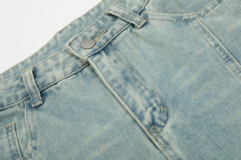 Close-up of front waistband, button closure, and pocket on light wash jeans