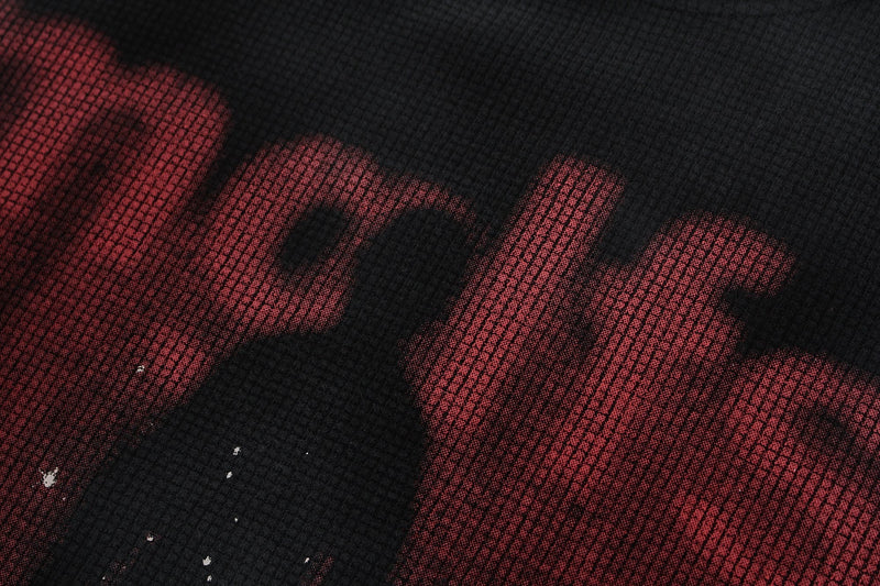 Close-up of a black washed oversized tee with bold red shadow figure graphic print