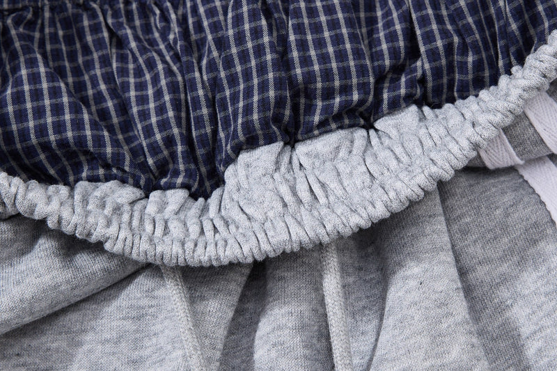 Close-up of plaid waistband layered over light gray elastic shorts