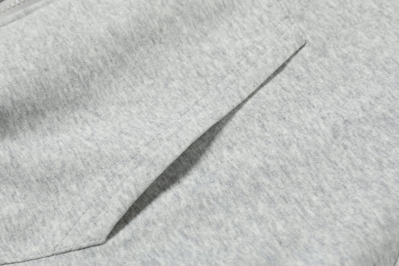 Light gray hoodie fabric close-up showing smooth knit and diagonal seam