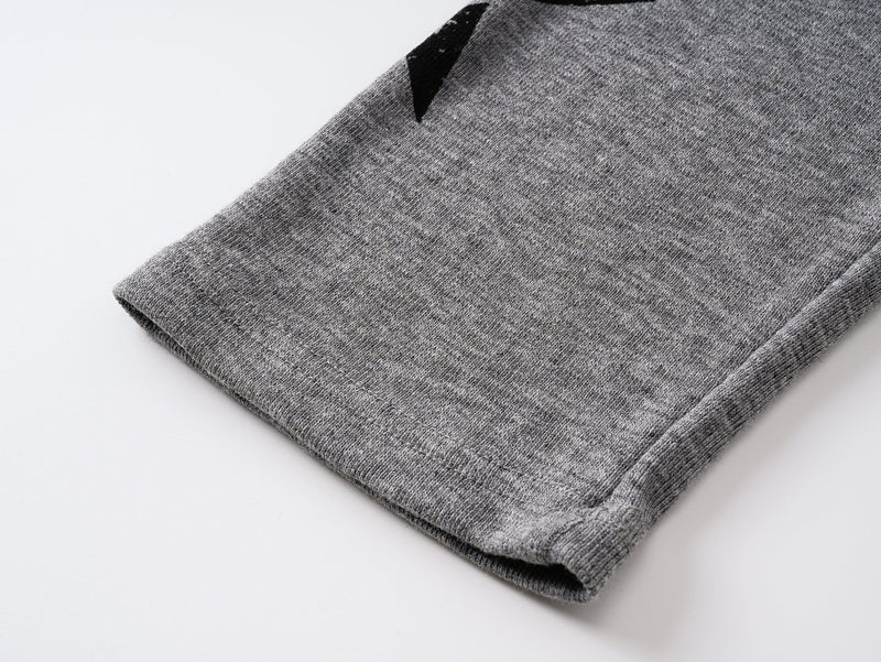 Close-up of gray tee cuff with ribbed hem and heathered knit texture