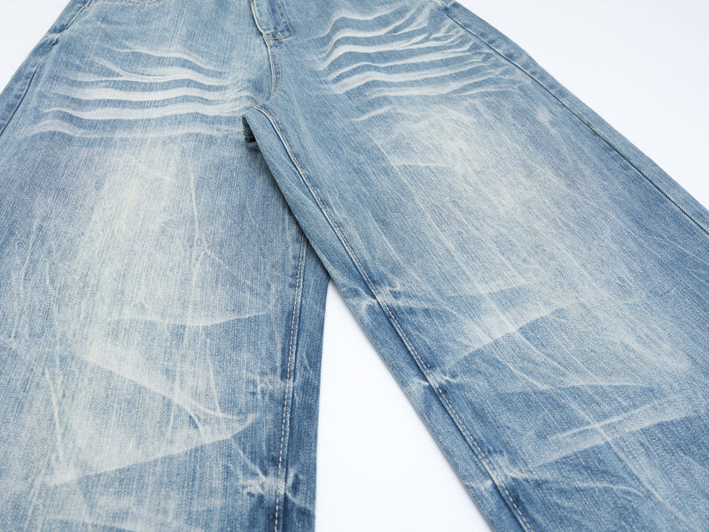 Wide-leg denim jeans shown from the lower leg area with heavy faded wash and crease marks