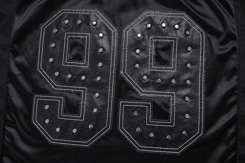 Close-up of studded 99 graphic on the back of a black varsity jersey