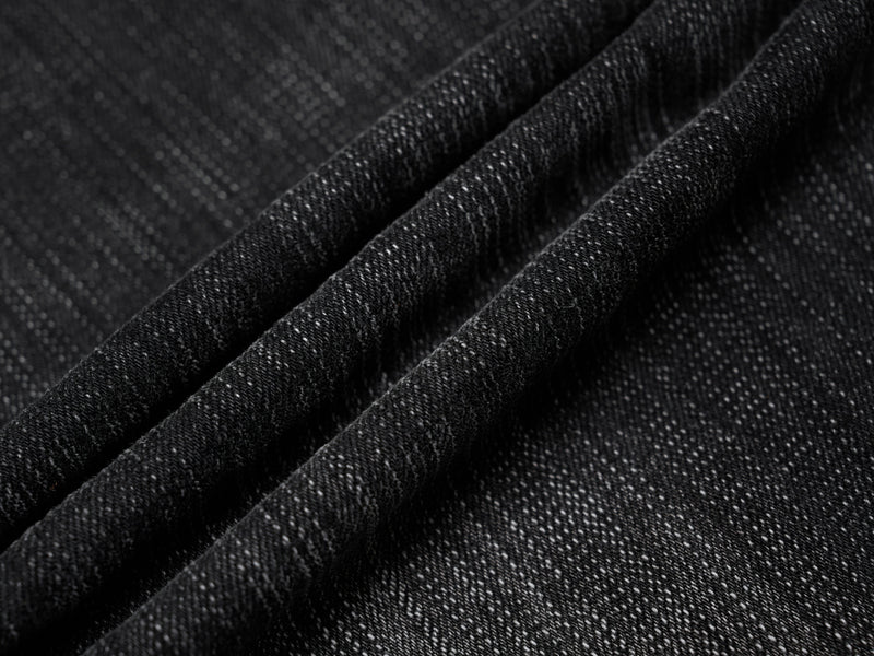 Close-up of black denim fabric texture with folded seams