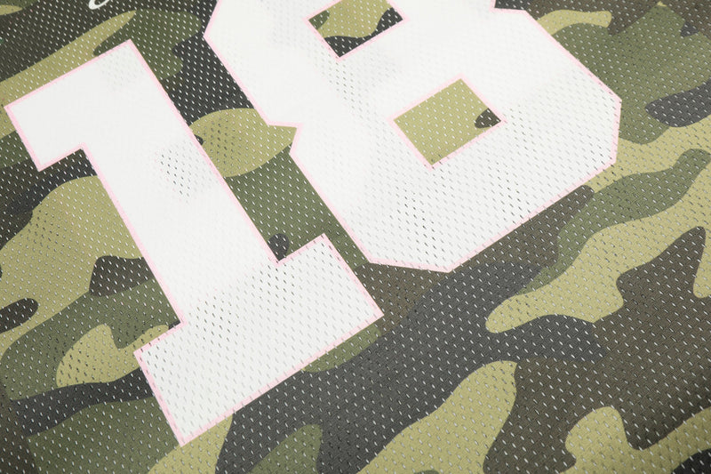 Close-up of a pink-outlined number 18 on a green and black camo mesh football jersey