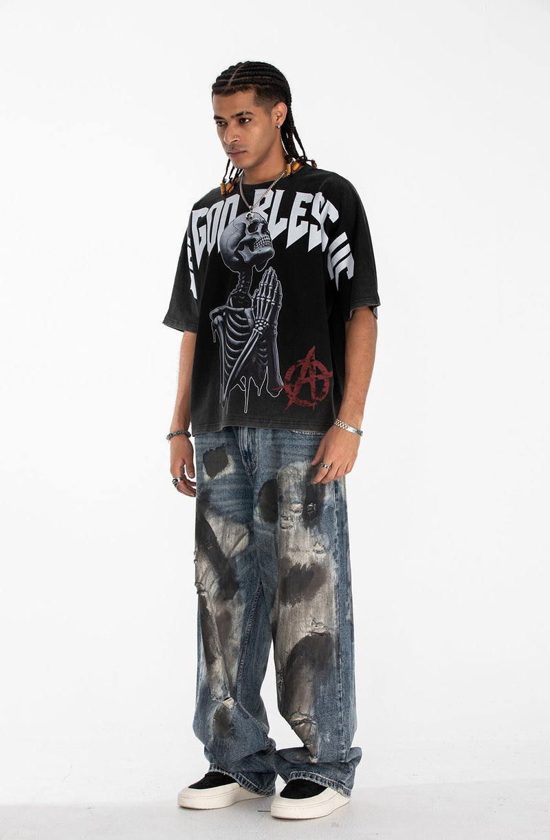 Oversized black gothic graphic tee with skeleton print and bold white lettering on a male model