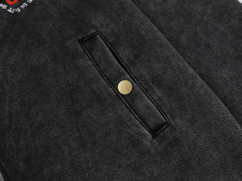 Close-up of black jacket side pocket with snap button and ribbed trim