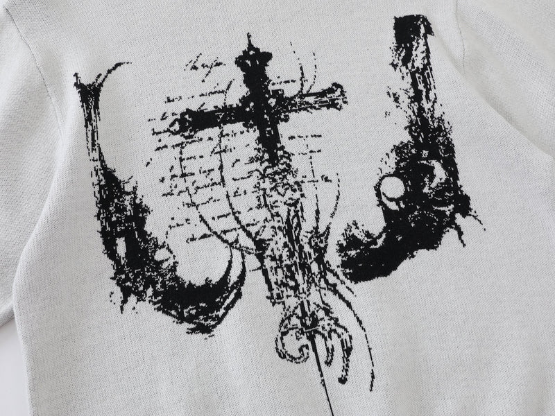 Close-up of black cross graphic on white knit sweater front