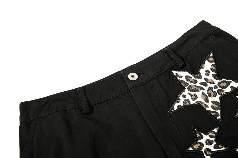 Close-up of black waistband with belt loops and leopard star patch detail