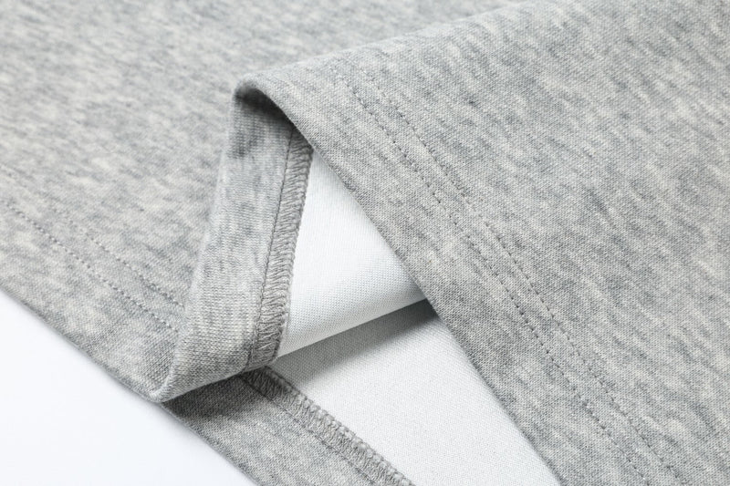 Close-up of sleeve seam and side opening on gray sweatshirt