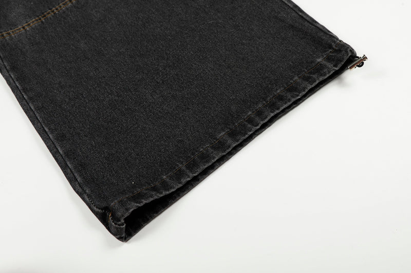 Cuffed hem of black washed wide-leg denim pants with side drawstring detail