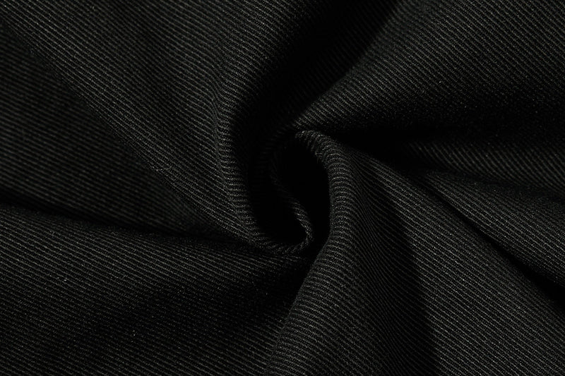 Close-up of black pant fabric with diagonal weave texture and folds