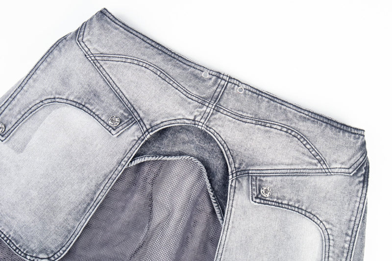 Close-up of the back waistband and mesh underlayer on gray distressed jeans