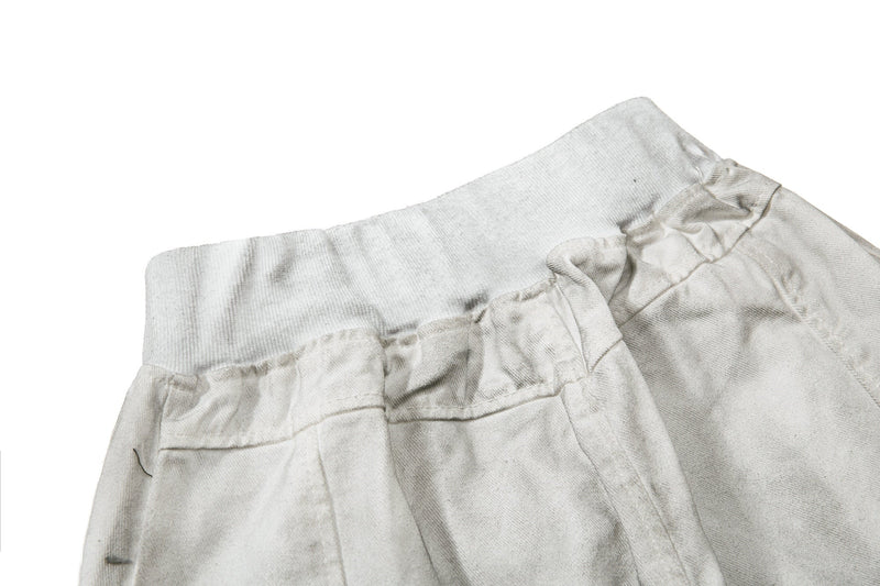 Close-up of the back waistband and seam detail on light gray denim shorts