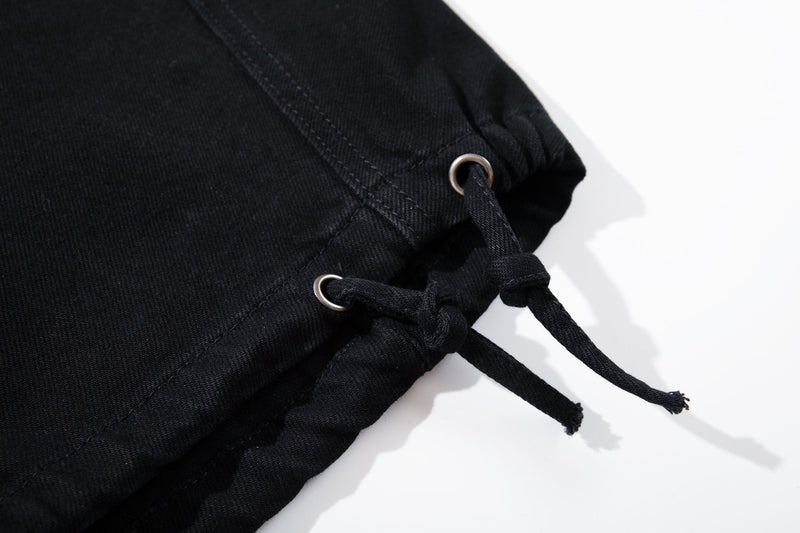 Close-up of black pant hem with drawcord loops and metal eyelets