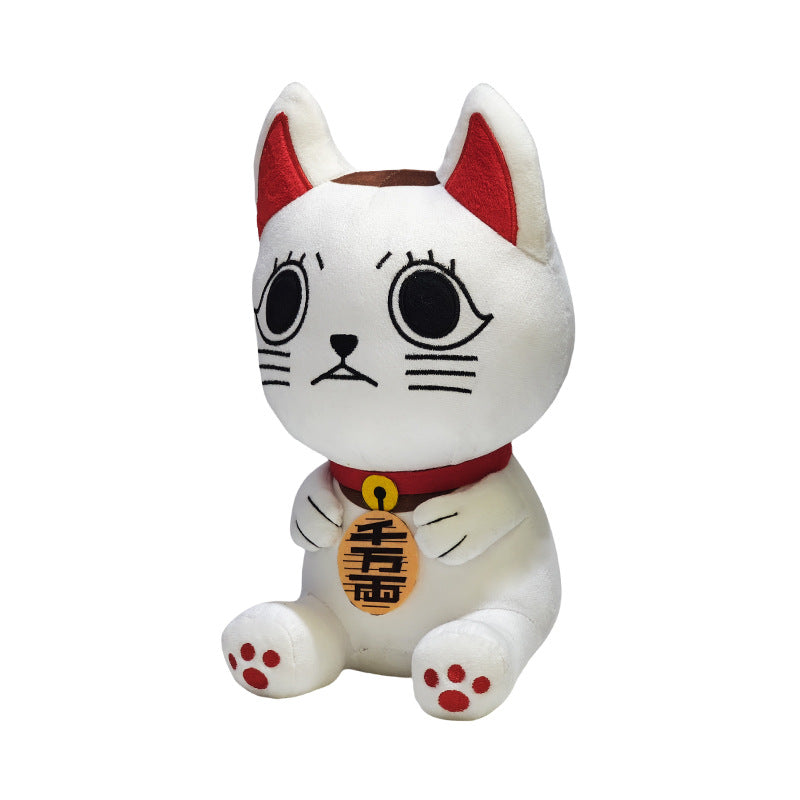 A white plush toy cat by Dandadan, made with high-quality PP cotton, features large black eyes, red ears, and a red collar. It holds a gold coin with black symbols and sits upright against a plain white background.