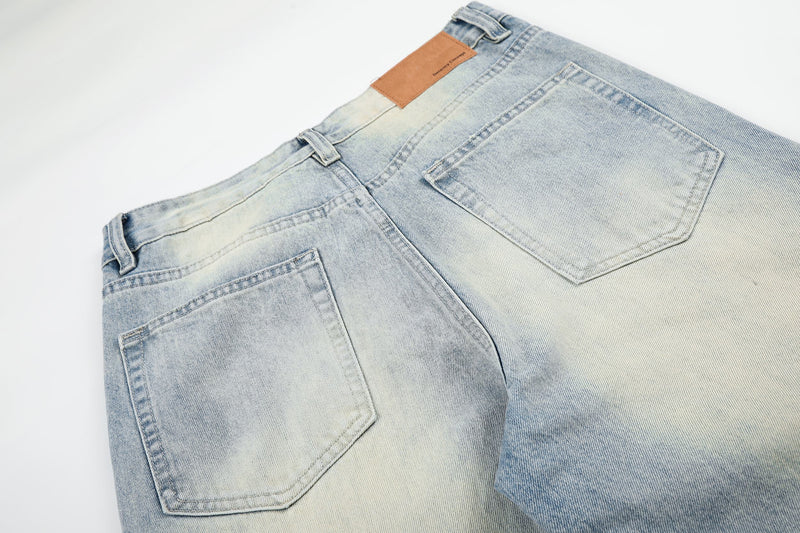 Back upper section of light wash jeans with patch pocket and brown waistband label