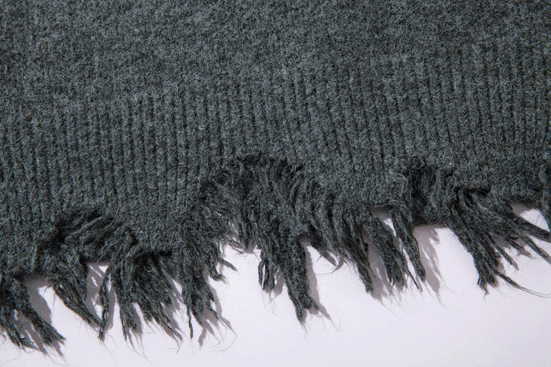 Close-up of frayed distressed hem on dark gray knit sweater