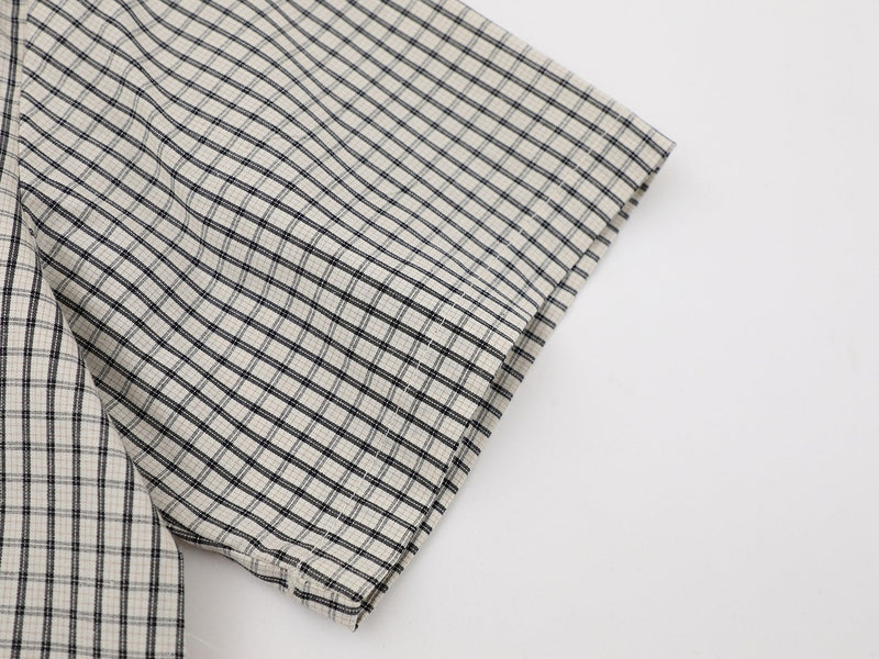 Beige and black plaid button-up shirt sleeve with crinkled textured fabric detail