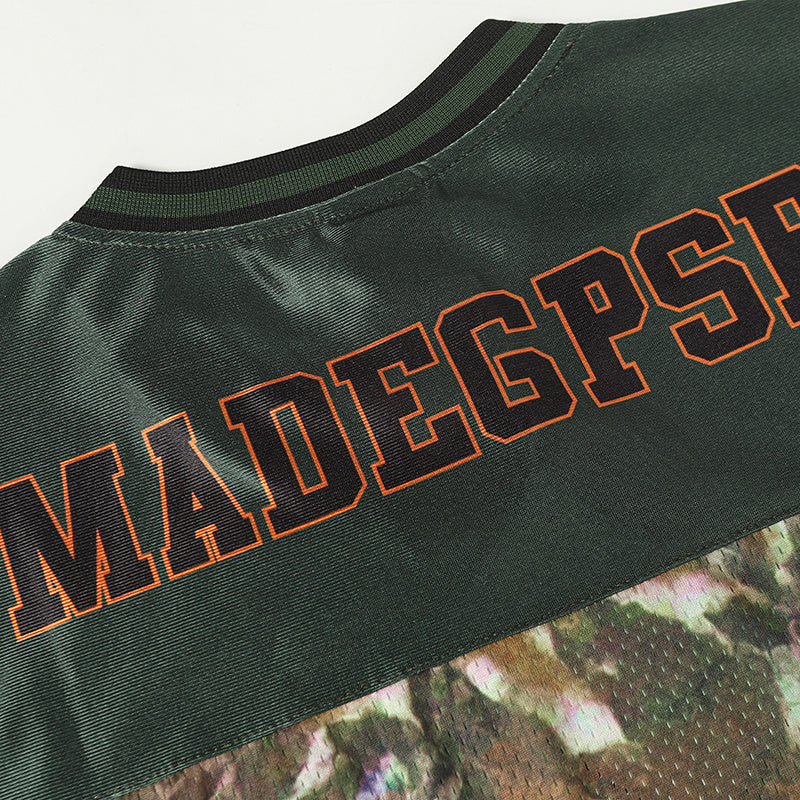 Dark green camo football jersey with orange outlined lettering and black ribbed collar, streetwear sports style
