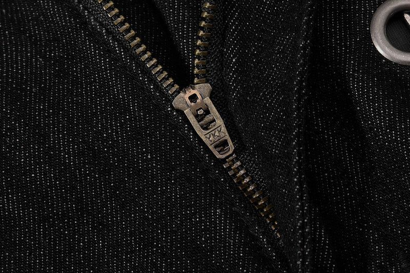 Close-up of zipper pull on black denim pants