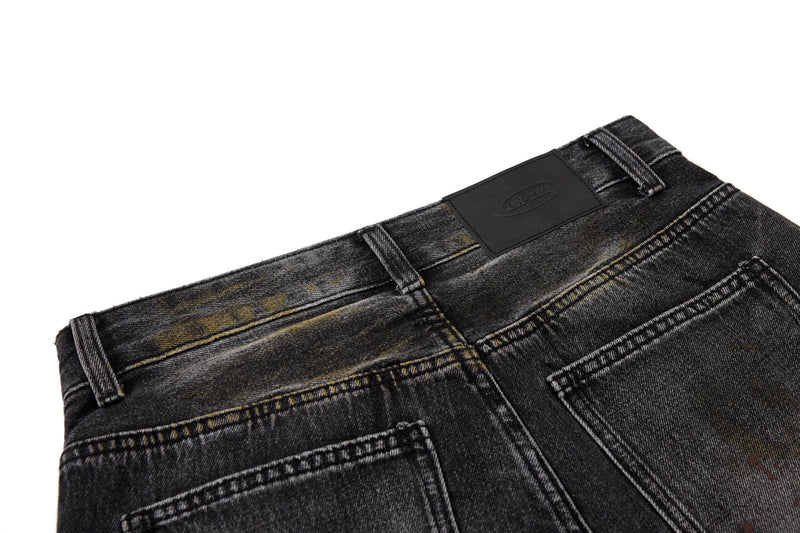 Close-up of back waistband and leather label on black vintage-washed denim pants