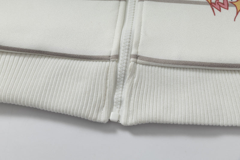 Close-up of lower hem and zipper on cream ribbed zip-up hoodie