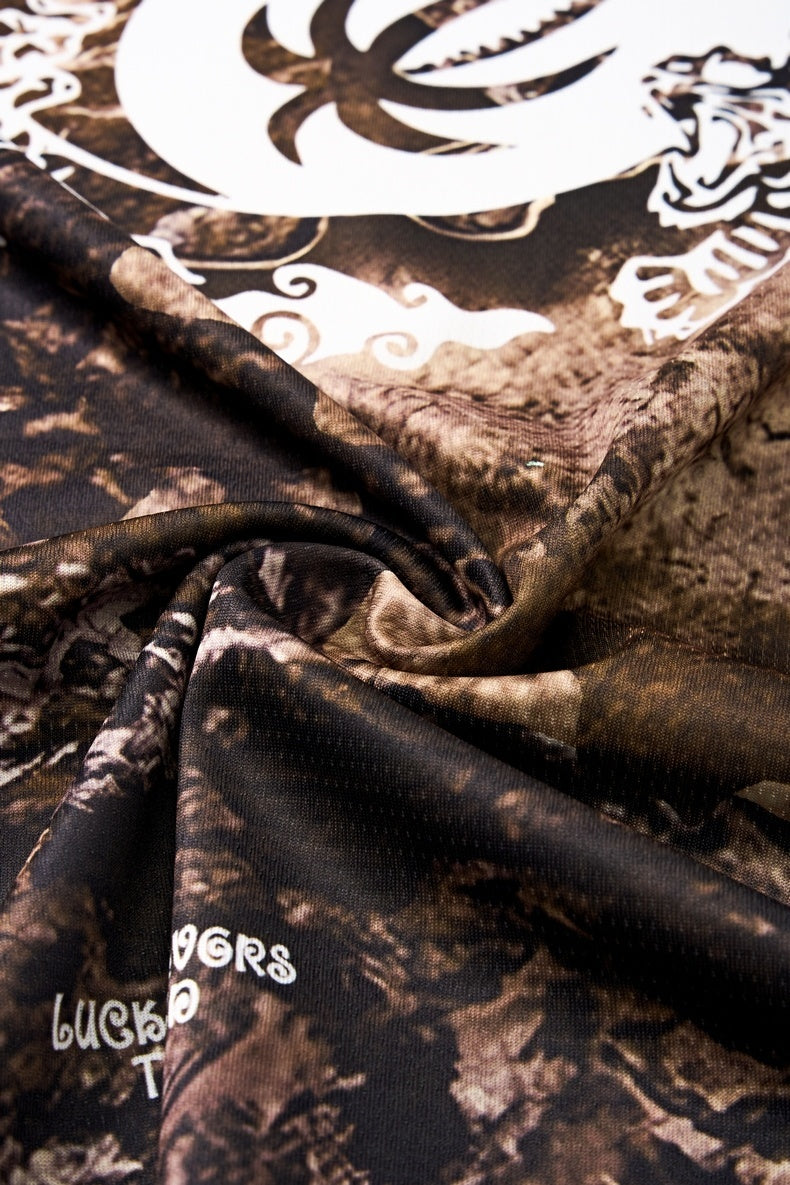 Close-up of a desert camo mesh tee with white graphic print and textured performance fabric