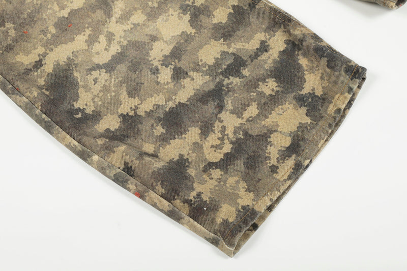 Close-up of wide-leg hem on camouflage denim pants with folded cuff and stitched edge