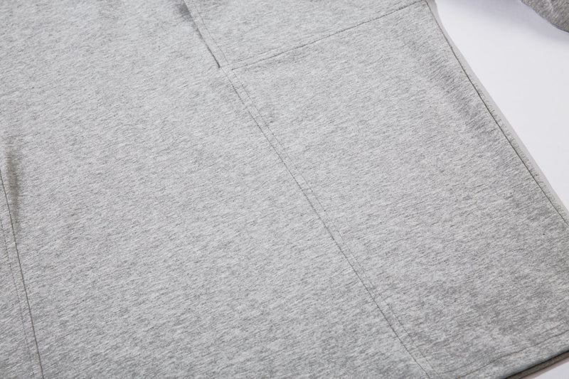 Close-up of the light gray tee body showing panel seams and soft heathered fabric