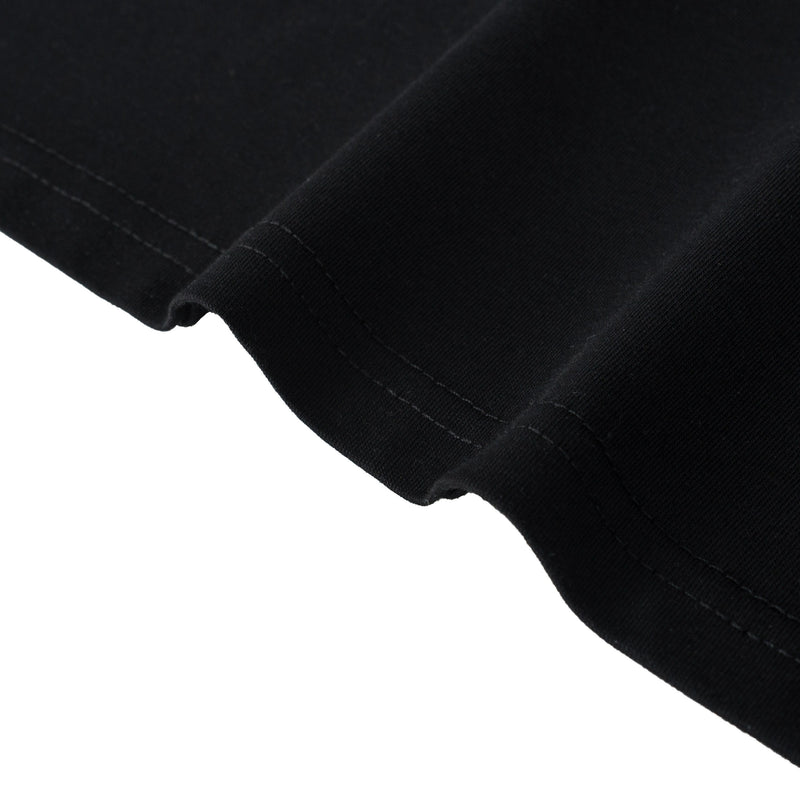 Close-up of a black polo tee hem with visible stitching and ribbed fabric texture