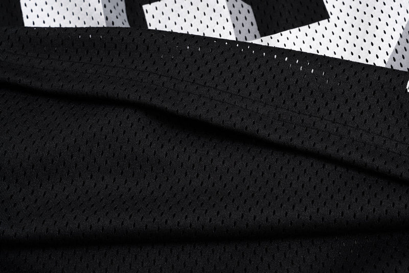 Close-up of black mesh jersey fabric with white number print above