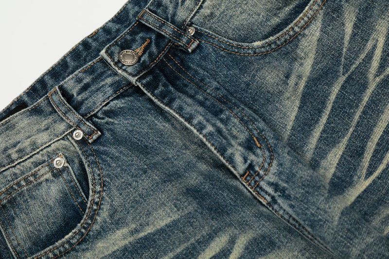 Close-up of front waistband, pocket edge, and faded wash on blue jeans