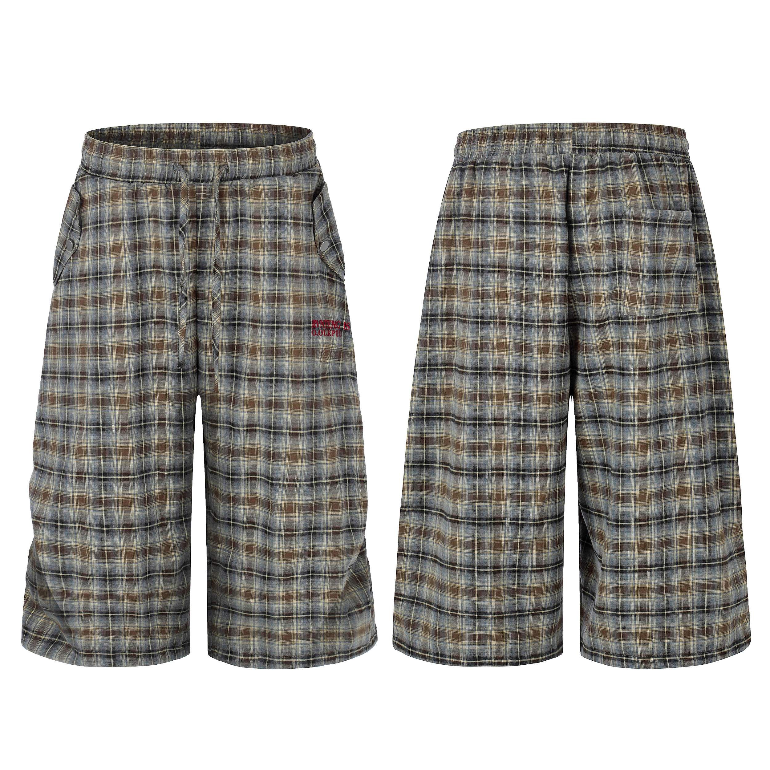 Front and back view of oversized brown and grey plaid lounge shorts with elastic drawstring waist and red embroidery