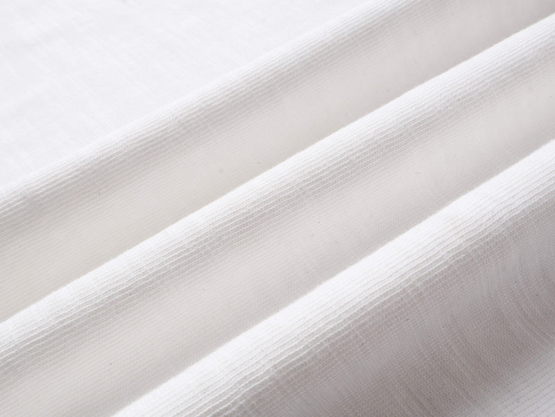 Close-up of white cotton fabric texture with diagonal folds