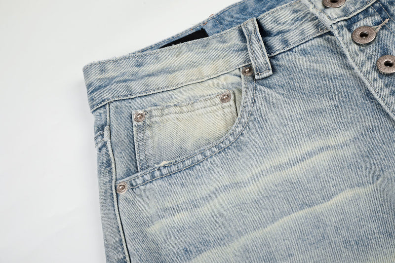 Close-up of the front pocket and button fly on washed light blue jeans