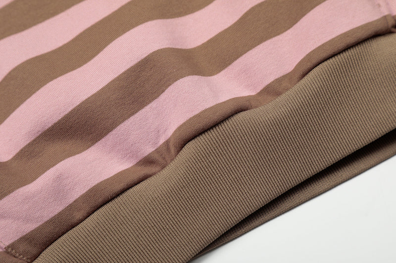 Close-up of ribbed hem on pink and brown striped hoodie