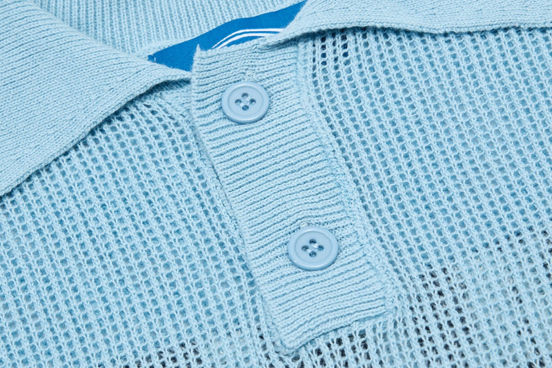 Light blue knit varsity polo with ribbed placket, two buttons, and textured mesh stitching close-up