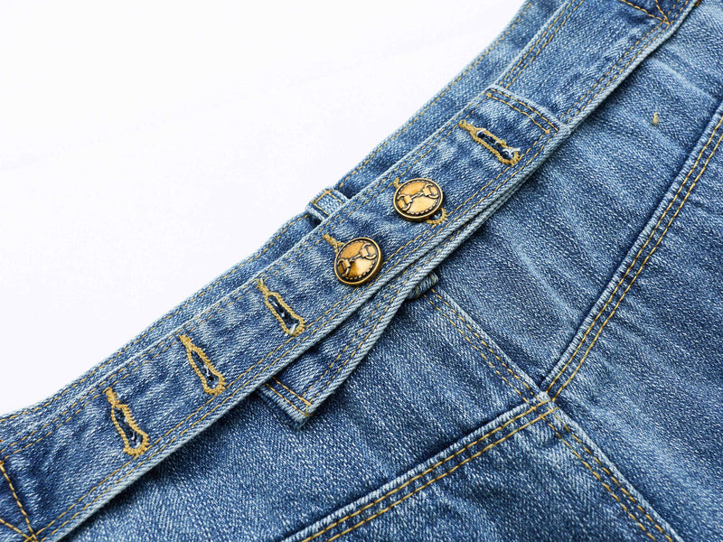 Close-up of the waistband and belt loop area on blue denim shorts with gold-tone buttons