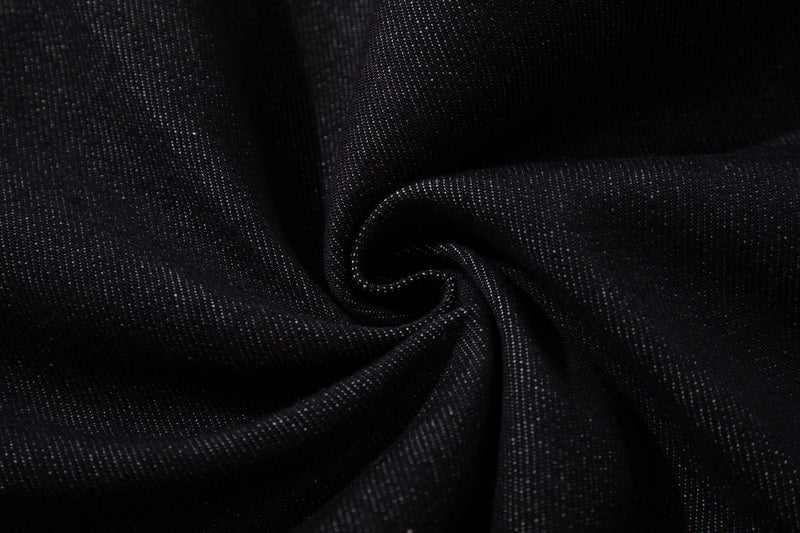Close-up of dark wash denim fabric texture with soft folds
