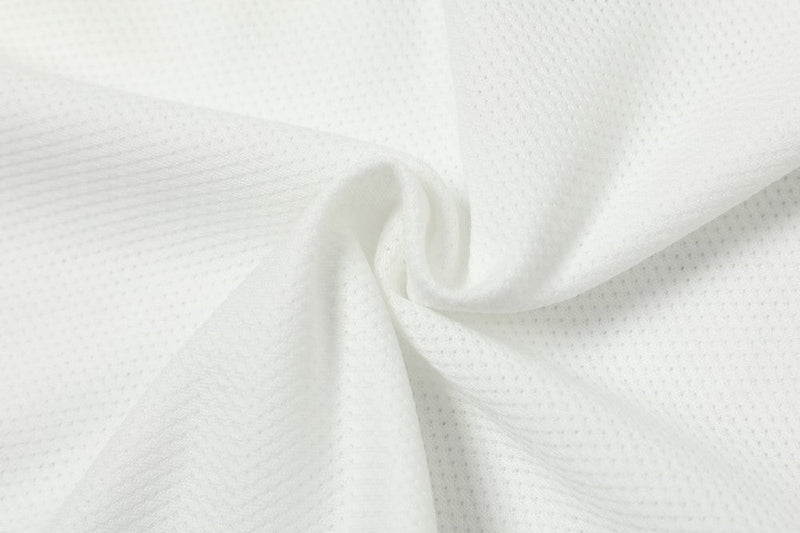 White mesh jersey fabric with a breathable perforated texture, shown in a close-up of the varsity football tee material
