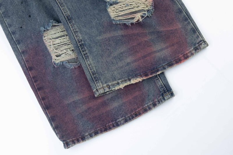 Close-up of the lower hem on faded distressed jeans with frayed edges and purple tint
