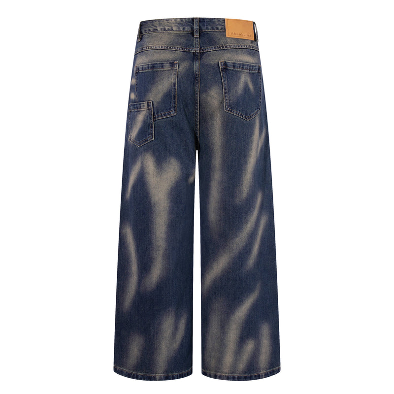 Back view of wide-leg jeans in vintage blue denim with smoke-fade finish and tan logo patch