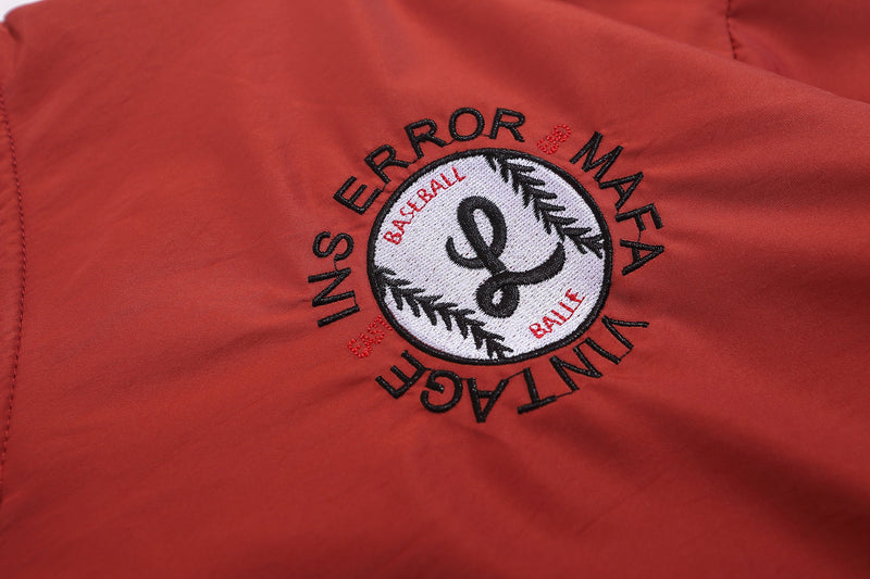 Close-up of red chest patch with circular INSERROR baseball-style embroidery