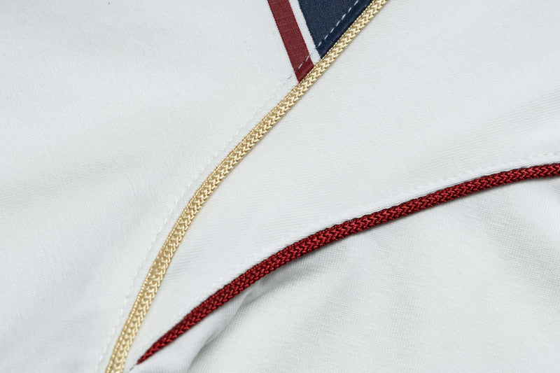 Close-up of white retro football jersey tee with gold piping, red trim, and navy accent stitching