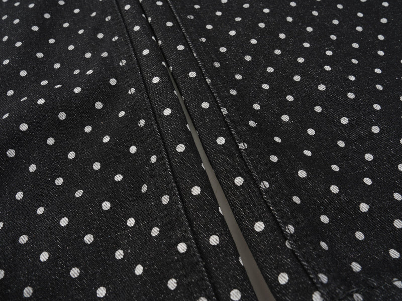 Close-up of black polka-dot denim fabric across the pant legs