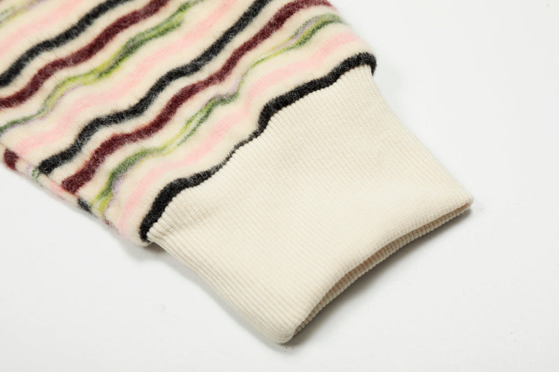 Close-up of cream ribbed cuff on striped knit hoodie sleeve